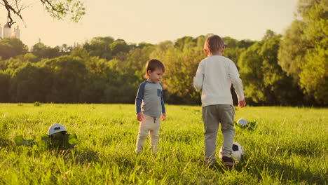 Two-cute-little-kids-playing-football-together-summertime.-Children-playing-soccer-outdoor